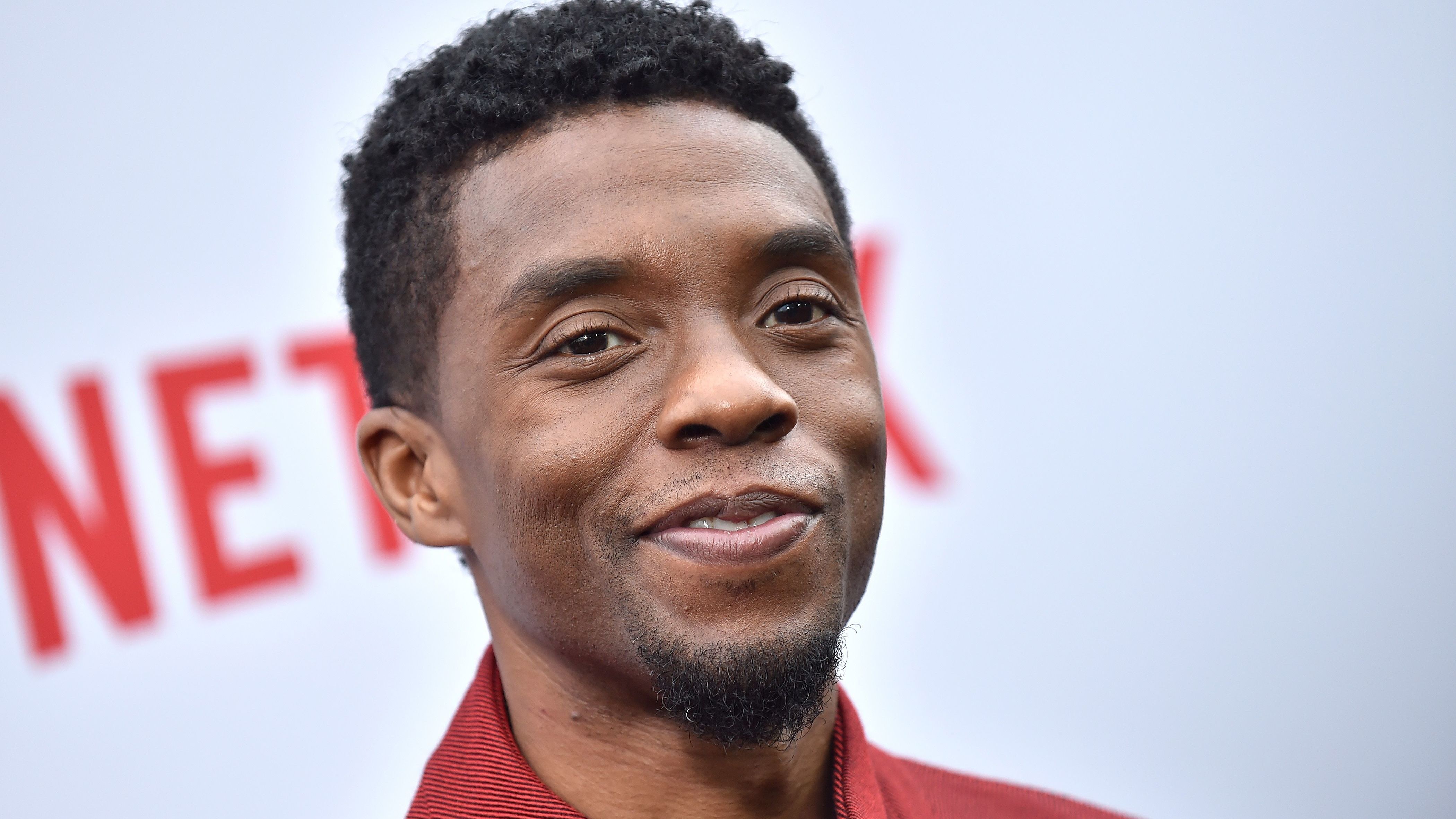 Boseman smiling at a Netflix premiere.